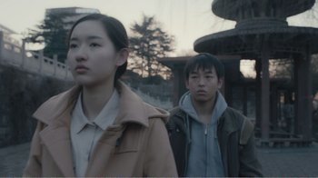 Movie still from “An Elephant Sitting Still” (2018), directed by Bo Hu – A man and a woman standing next to each other; Medium shot, Low angle