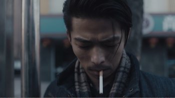 Movie still from “An Elephant Sitting Still” (2018), directed by Bo Hu – A man with a cigarette in his mouth; Close Up shot, Low angle
