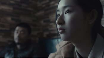 Movie still from “An Elephant Sitting Still” (2018), directed by Bo Hu – A young asian woman looking into the distance; Close Up shot, Over the shoulder angle
