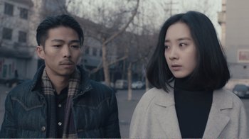 Movie still from “An Elephant Sitting Still” (2018), directed by Bo Hu – A man and a woman standing next to each other on the sidewalk; Close Up shot, Low angle