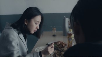 Movie still from “An Elephant Sitting Still” (2018), directed by Bo Hu – A woman sitting at a table with a plate of food; Close Up shot, Over the shoulder angle