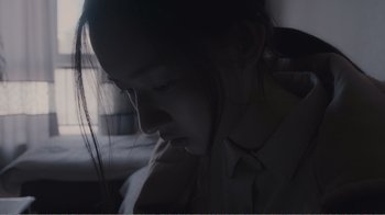 Movie still from “An Elephant Sitting Still” (2018), directed by Bo Hu – A woman is looking down at her face; Close Up shot, High angle