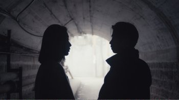 Movie still from “An Elephant Sitting Still” (2018), directed by Bo Hu – Two people standing side by side in a tunnel; Close Up shot, Low angle