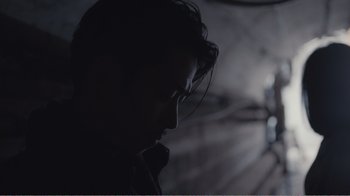 Movie still from “An Elephant Sitting Still” (2018), directed by Bo Hu – A man with long dark hair looking down at the ground; Close Up shot, Low angle