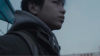 Movie still from “An Elephant Sitting Still” (2018), directed by Bo Hu – A person wearing a hooded jacket; Extreme Close Up shot, Low angle