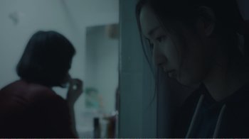 Movie still from “An Elephant Sitting Still” (2018), directed by Bo Hu – A woman looking out of a bathroom window at a man; Close Up shot, Over the shoulder angle