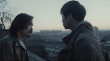 Movie still from “An Elephant Sitting Still” (2018), directed by Bo Hu – Two young people standing next to each other on a bridge; Close Up shot, Over the shoulder angle