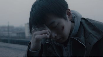 Movie still from “An Elephant Sitting Still” (2018), directed by Bo Hu – A young man with a bandage on his face; Close Up shot, High angle