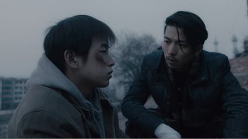 Movie still from “An Elephant Sitting Still” (2018), directed by Bo Hu – Two young men sitting next to each other on the ground; Close Up shot, Over the shoulder angle