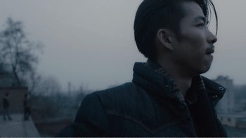 Movie still from “An Elephant Sitting Still” (2018), directed by Bo Hu – A person wearing a jacket; Close Up shot, Over the shoulder angle