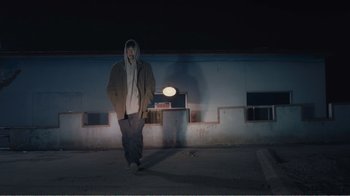 Movie still from “An Elephant Sitting Still” (2018), directed by Bo Hu – A man standing in front of a building at night; Wide shot, Low angle