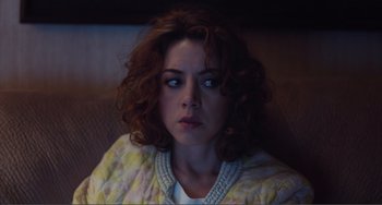 Movie still from “An Evening with Beverly Luff Linn” (2018), directed by Jim Hosking – A person sitting on a couch; Close Up shot, High angle