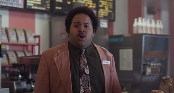 Movie still from “An Evening with Beverly Luff Linn” (2018), directed by Jim Hosking – A man in a pink jacket and a brown tie; Medium shot, Low angle