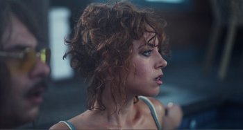 Movie still from “An Evening with Beverly Luff Linn” (2018), directed by Jim Hosking – A person with curly brown hair; Close Up shot, Low angle