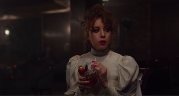 Movie still from “An Evening with Beverly Luff Linn” (2018), directed by Jim Hosking – A woman holding a drink in her hand; Close Up shot, Over the shoulder angle