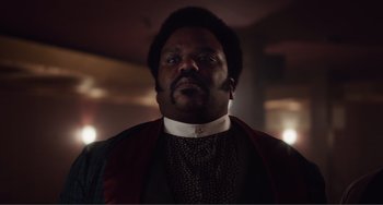 Movie still from “An Evening with Beverly Luff Linn” (2018), directed by Jim Hosking – A person wearing a suit and tie; Close Up shot, Low angle