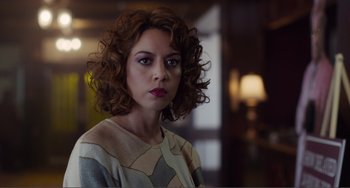 Movie still from “An Evening with Beverly Luff Linn” (2018), directed by Jim Hosking – A person with curly hair; Close Up shot, Over the shoulder angle