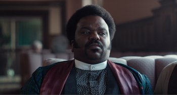 Movie still from “An Evening with Beverly Luff Linn” (2018), directed by Jim Hosking – A person wearing a suit and tie; Close Up shot, Low angle