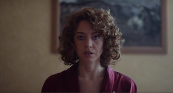 Movie still from “An Evening with Beverly Luff Linn” (2018), directed by Jim Hosking – A person with curly brown hair; Close Up shot, Over the shoulder angle