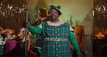 Movie still from “An Evening with Beverly Luff Linn” (2018), directed by Jim Hosking – A man dressed in a green outfit and holding a staff; Medium shot, Low angle