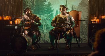 Movie still from “An Evening with Beverly Luff Linn” (2018), directed by Jim Hosking – A couple of men playing instruments on a stage; Wide shot, High angle