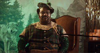 Movie still from “An Evening with Beverly Luff Linn” (2018), directed by Jim Hosking – A man dressed as a leprechaun sitting in a chair; Medium shot, Low angle