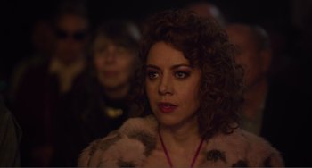 Movie still from “An Evening with Beverly Luff Linn” (2018), directed by Jim Hosking – A person with curly hair wearing a fur coat; Close Up shot, Over the shoulder angle