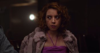 Movie still from “An Evening with Beverly Luff Linn” (2018), directed by Jim Hosking – A person wearing a dress and a fur coat; Close Up shot, Over the shoulder angle
