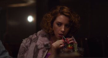 Movie still from “An Evening with Beverly Luff Linn” (2018), directed by Jim Hosking – A woman with red hair is holding a glass of juice; Close Up shot, Over the shoulder angle