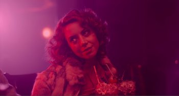 Movie still from “An Evening with Beverly Luff Linn” (2018), directed by Jim Hosking – A beautiful woman with red curly hair holding a bowl of food; Close Up shot, Over the shoulder angle