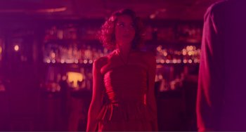 Movie still from “An Evening with Beverly Luff Linn” (2018), directed by Jim Hosking – A woman in a red dress standing in front of a bar; Medium shot, Low angle