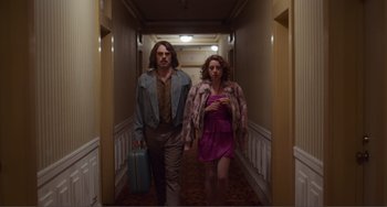 Movie still from “An Evening with Beverly Luff Linn” (2018), directed by Jim Hosking – A man and a woman walking down a hall way; Medium shot, Low angle