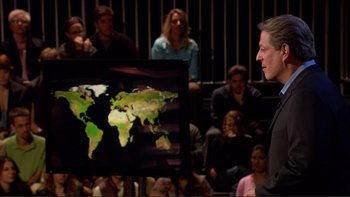 Movie still from “An Inconvenient Truth” (2006), directed by Davis Guggenheim – A man standing in front of a screen with a map on it; Medium shot, High angle