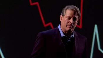 Movie still from “An Inconvenient Truth” (2006), directed by Davis Guggenheim – A man in a suit and tie standing in front of a red background; Medium shot, Low angle