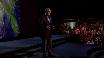Movie still from “An Inconvenient Truth” (2006), directed by Davis Guggenheim – A man standing on a stage in front of an audience; Wide shot, Over the shoulder angle