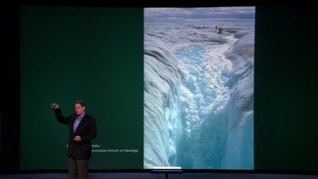 Movie still from “An Inconvenient Truth” (2006), directed by Davis Guggenheim – A man standing in front of a large screen; Extreme Wide shot, Overhead angle