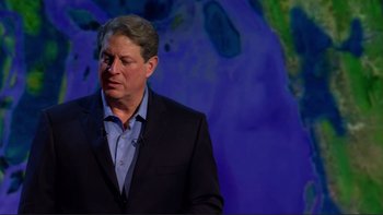 Movie still from “An Inconvenient Truth” (2006), directed by Davis Guggenheim – A man in a black suit standing in front of a purple background; Close Up shot, Low angle