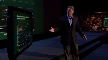 Movie still from “An Inconvenient Truth” (2006), directed by Davis Guggenheim – A man standing in front of a large screen tv; Medium shot, Over the shoulder angle