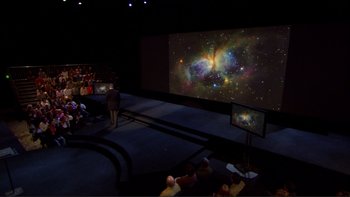 Movie still from “An Inconvenient Truth” (2006), directed by Davis Guggenheim – People are sitting in front of a projection screen; Extreme Wide shot, High angle