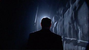 Movie still from “An Inconvenient Truth” (2006), directed by Davis Guggenheim – A man in a suit is standing in the dark; Medium shot, Low angle