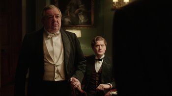 Movie still from “An Inspector Calls” (2015), directed by Raymond Pak-Ming Wong – A man and a young boy in a suit and bow tie; Medium shot, Over the shoulder angle