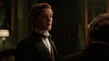 Movie still from “An Inspector Calls” (2015), directed by Raymond Pak-Ming Wong – A man wearing a suit and bow tie; Close Up shot, Over the shoulder angle