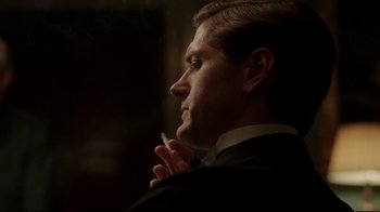 Movie still from “An Inspector Calls” (2015), directed by Raymond Pak-Ming Wong – A person wearing a suit holding a cigarette; Close Up shot, Over the shoulder angle