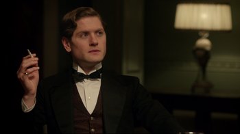 Movie still from “An Inspector Calls” (2015), directed by Raymond Pak-Ming Wong – A man in a suit and bow tie looking to his left; Close Up shot, Over the shoulder angle