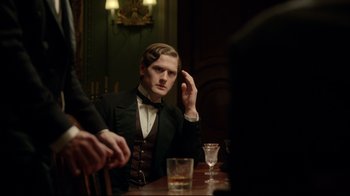 Movie still from “An Inspector Calls” (2015), directed by Raymond Pak-Ming Wong – A man sitting at a table with a glass of whiskey; Medium shot, Over the shoulder angle