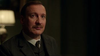 Movie still from “An Inspector Calls” (2015), directed by Raymond Pak-Ming Wong – An older man wearing a suit and a tie; Close Up shot, Over the shoulder angle