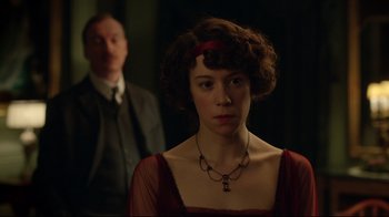 Movie still from “An Inspector Calls” (2015), directed by Raymond Pak-Ming Wong – A woman in a red dress standing in front of a man in a suit; Close Up shot, Over the shoulder angle