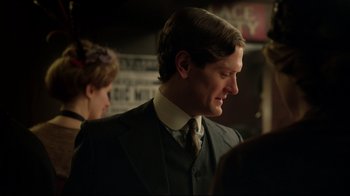 Movie still from “An Inspector Calls” (2015), directed by Raymond Pak-Ming Wong – A man wearing a suit and tie standing next to a woman; Close Up shot, Over the shoulder angle