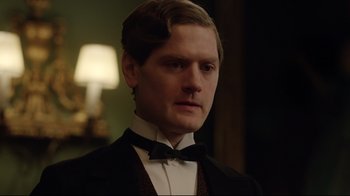 Movie still from “An Inspector Calls” (2015), directed by Raymond Pak-Ming Wong – A man wearing a suit and bow tie; Close Up shot, Over the shoulder angle