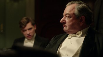 Movie still from “An Inspector Calls” (2015), directed by Raymond Pak-Ming Wong – A man in a tuxedo and a young man in a suit; Close Up shot, Over the shoulder angle